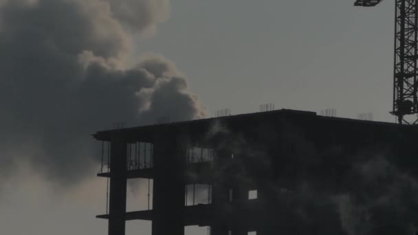 家の建物。煙の背景にシルエット クレーン. — ストック動画