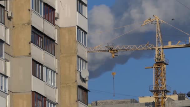 Byggnaden av hus. Kran på himmel bakgrund och rök. — Stockvideo