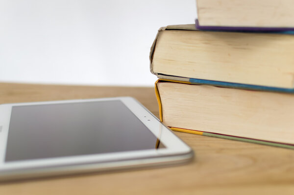 Hardcover books next to a tablet