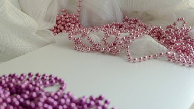 Beyaz arka planda tatil renkli boncuklar. beyaz üzerine pembe