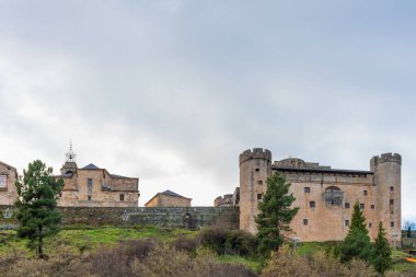 Eski Puebla de Sanabria kasabasının panoramik manzarası sağında şatosu, kilisesi, evleri ve duvarları akşam saatlerinde Noel ışıklarıyla süslenmiş.
