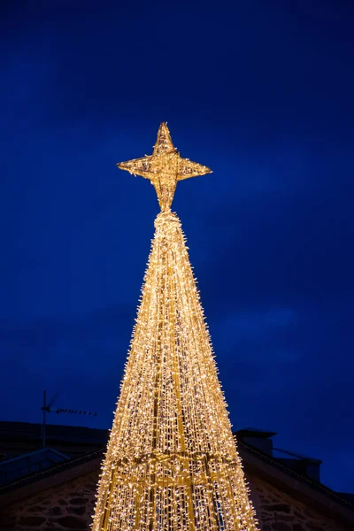 Aydınlatılmış Noel ağacının dikey görüntüsü ve Puebla de Sanabria dekorasyonunun yıldızı