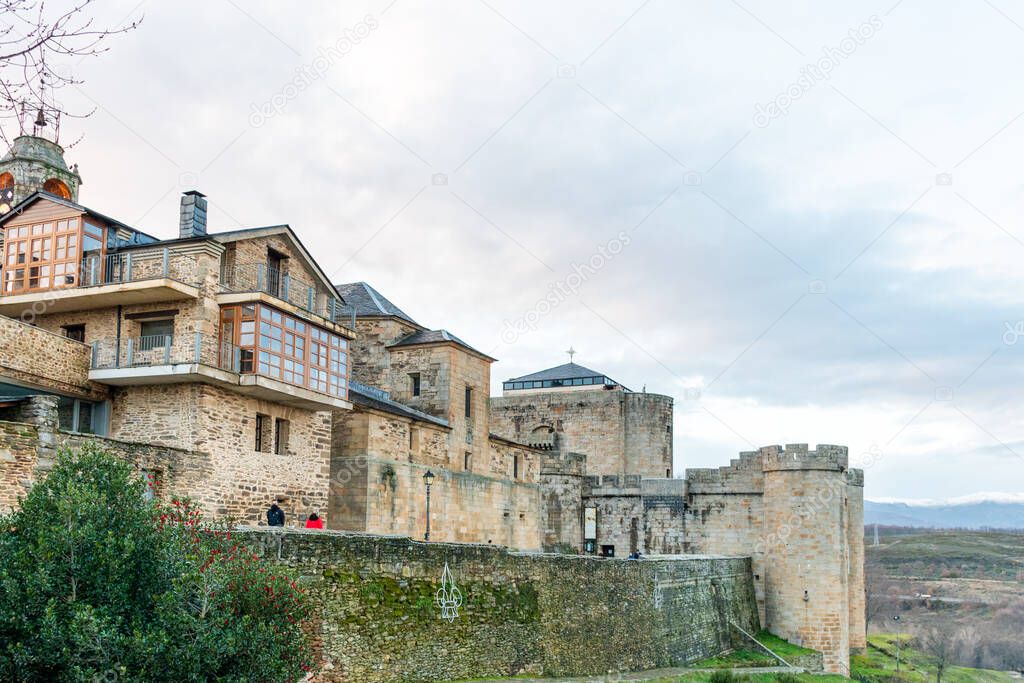 Horizontal view of the wall, house and stone castle of Puebla de Sanabria decorated with Christmas lights 2020 with people