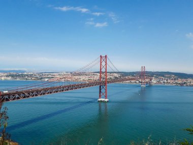Güneşli bir günde Lizbon 'un kırmızı asma köprüsü. Arka planda Portekiz köprüsü var. San Francisco köprüsüne benzer.
