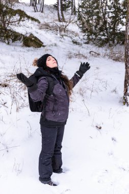 Beyaz, beyaz, beyaz bir kadın. Karda kolları açık gökyüzüne bakıyor. Kavram, karları yüzünde hisset. Kışa hoş geldiniz.