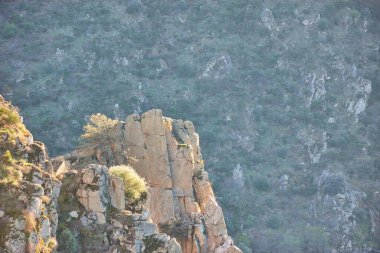 Gün batımında kayalıkları olan üç kayalık dağ. İspanya ile Portekiz arasındaki sınır, Arribes del Duero