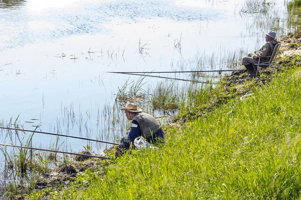 Pescatore in una giornata di pesca estiva sul fiume su un galleggiante — Foto Stock