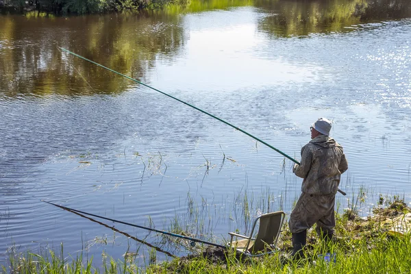 Pescador em um dia de verão pescando no rio em um flutuador — Fotografia de Stock