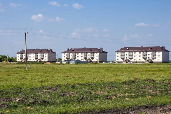 Village Morshanskoe, Kargatskiy rayon, Novosibirskaya oblast, Siberia, Russia - June 12, 2016: new modern three-storied apartment house on the outskirts of the village