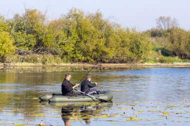 Nehrin Chaus, Kolyvan bölgesi, Novosibirsk Oblastı, Sibirya, Rusya - 17 Eylül 2016: hava ile şişirilen kürek tekne yırtıcı bir balık Nehri üzerinde arıyorsunuz bir iplik çubuk ile balıkçılar