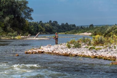 Berd Nehri, İskitim Bölgesi, Novosibirsk Bölgesi, Batı Sibirya, Rusya-11 Ağustos 2020: Berd Nehri kıyısında bir balıkçı balık yakalar