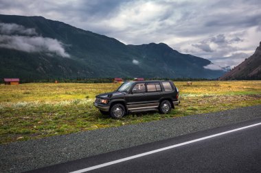 ULAGANSKY DISTRICT, Altai Cumhuriyeti, RUSSIA-22 Temmuz 2020: Chuysky yolunun yanında bir SUV duruyor