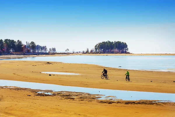 Ciclisti a cavallo sulla riva del fiume poco profondo — Foto Stock