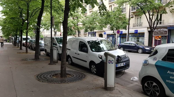 Birçok araba bir kuyruğa park edilmiştir. Yol boyunca uzanan elektrikli araç şarj istasyonunda, Paris, Fransa 2019 / 04 / 29