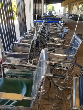 Hastane yatağı ve tekerlekli sandalye hastaları hastanenin önünde bekliyor..