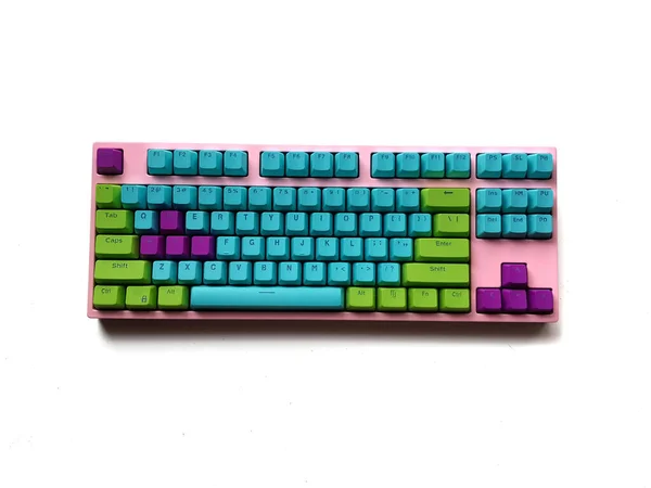 Pink keyboard with bright blue purple green key, unicorn color theme style on white background.