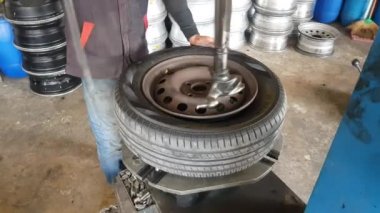 Modern aletlerle bir araba lastiğinin nasıl çıkarılacağını. Bangkok, Tayland: 01-05-2021