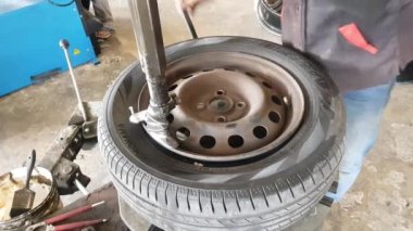 Modern aletlerle bir araba lastiğinin nasıl çıkarılacağını. Bangkok, Tayland: 01-05-2021