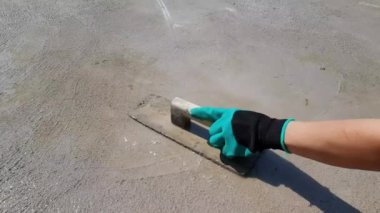 İşçiler beton zemini pürüzsüzleştirmek için bir mala kullanırlar..