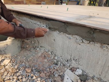 İnşaat işçileri zemini kaplamak için yere bir çelik döşeme alıyor..