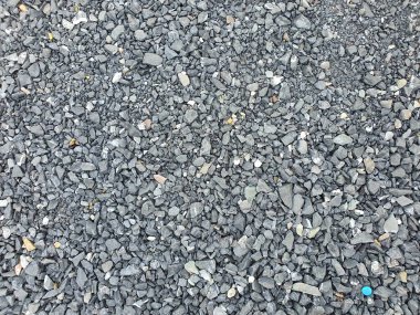 Taş duvar kağıdı kaba çakıl bir yol için düz bir yüzeye döküldü..