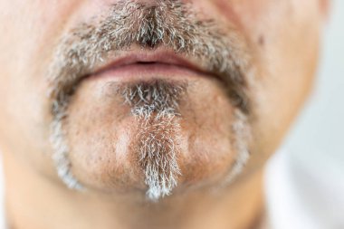 Bıyıklı ve sakallı adamın yakın görüntüsü.