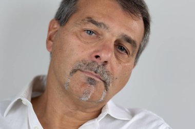 Olgun yakışıklı adam kameraya bakıyor.