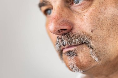 Duygusuz görünen sakallı bir adama yaklaş.