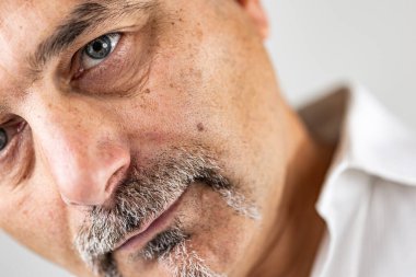 Sakallı adam dik duruyor.