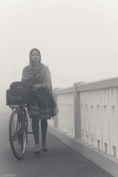 Kız sabah sisin içinde bir bisiklet ile