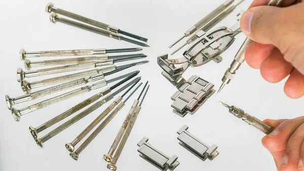 Bahar barı aletini kullanan bir saatçi. Yay çubuklarını kaldırmak için kullanılan yay çubuğu aracı saat kayışını değiştirmek için.