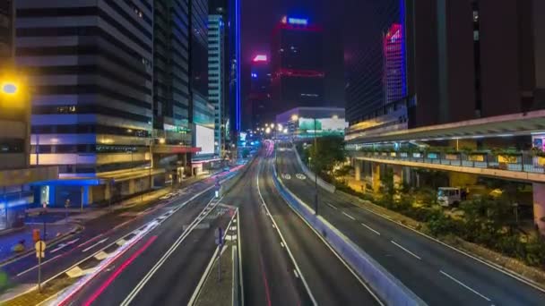 Hong Kong Business District timelapse en la noche. Edificio corporativo en la parte trasera y tráfico ocupado a través de la carretera principal en hora punta . — Vídeo de stock