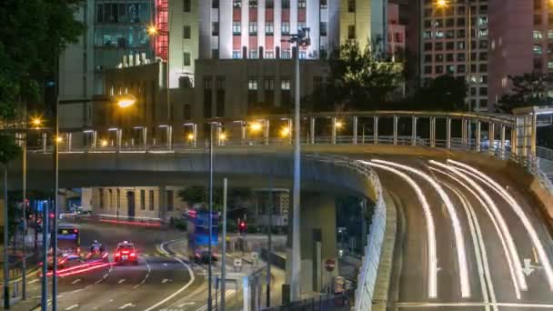 Hong Kong Business District timelapse en la noche. Edificio corporativo en la parte trasera y tráfico ocupado a través de la carretera principal en hora punta . — Vídeo de stock