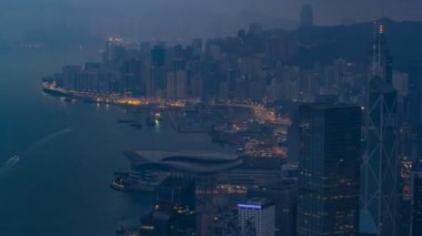 Victoria Peak gece gündüz timelapse Hong Kong ünlü görünümü. Kowloon Körfezi üzerinde renkli bulutlar ile gün doğumundan önce alınan.