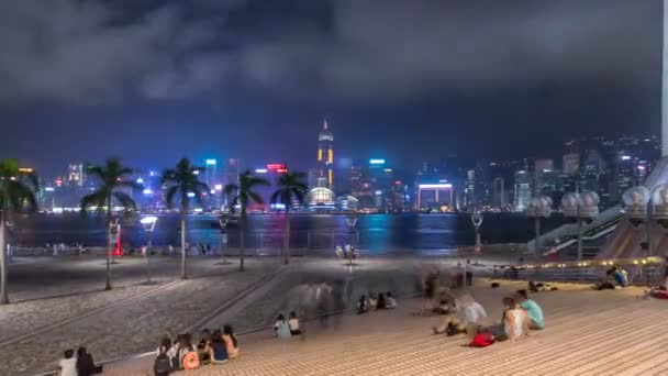 Ciudad de Hong Kong skyline por la noche sobre Victoria Harbor con cielo despejado y rascacielos urbanos timelapse hyperlapse . — Vídeos de Stock