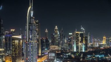 Geceleri doğal Dubai şehir manzarası timelapse. Şeyh Zayed caddesi üzerinde çok sayıda ışıklı Kuleli çatı görünümü.