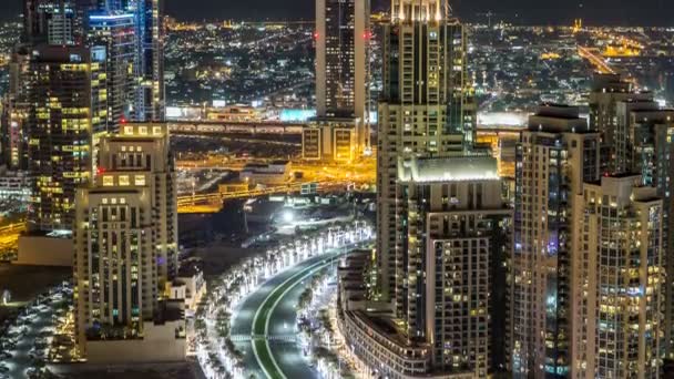 Top view of road in Dubai downtown timelapse with night traffic and illuminated skyscrapers. — Stock Video