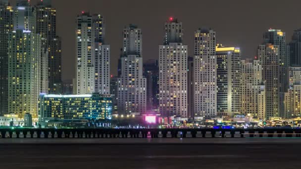 Dubai Marina skyline noite timelapse como visto de Palm Jumeirah em Dubai, Emirados Árabes Unidos . — Vídeo de Stock