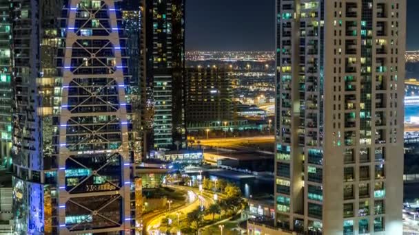 Edificios de Jumeirah Lakes Torres con tráfico en la carretera noche timelapse. — Vídeo de stock