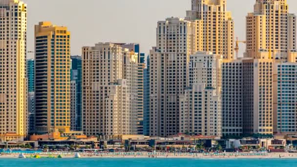 Jumeirah Beach Residence as seen from the palm jumeirah with sea timelapse. Dubai, United Arab Emirates — Stock Video