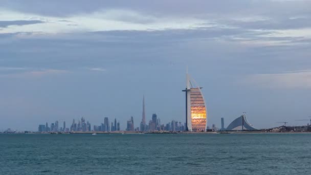 Dubai Skyline mit Burj Al Arab Hotel bei Sonnenuntergang und Tag-Nacht-Zeitraffer. — Stockvideo