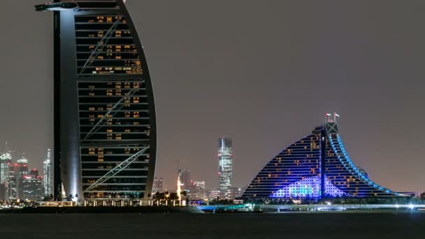 Skyline of Dubai w nocy timelapse z Burj al Arab na pierwszym planie w Dubaju, Zjednoczone Emiraty Arabskie — Wideo stockowe