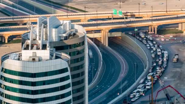 Luchtfoto van een kruising van de snelweg in Dubai, Verenigde Arabische Emiraten, bij zonsondergang met verkeerstijden. — Stockvideo