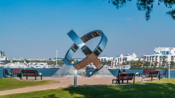 Ring monument, bench, green lawn, flowers and trees at Dubai Creek park timelapse. Dubai, United Arab Emirates — Stock Video