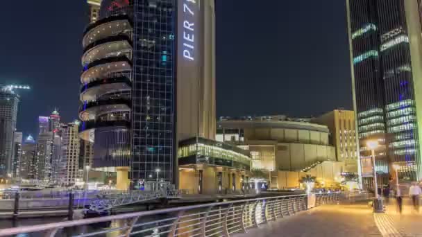 Corra no calçadão da Marina do Dubai com vista para torres e canal no hiperlapso da linha do tempo da noite do Dubai — Vídeo de Stock