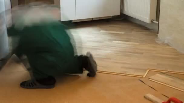 Carpenter Worker Installing Wood Parquet Board During Flooring