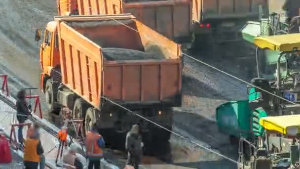 Descarga do dumper da extremidade traseira Asfalto na máquina do espalhador do pavimento no edifício de reparação rodoviária obras timelapse — Vídeo de Stock