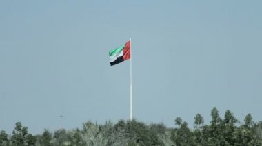 Temiz ve sakin gökyüzü karşı uçan bir Birleşik Arap Emirlikleri bayrağı. BAE, Ulusal Günü 2 Aralık'ta her yıl kutluyor..