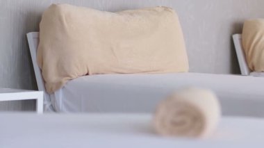 Havuzun yanındaki yatakta haddelenmiş portakal havlu yerleştirilir