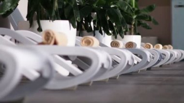 Havuzun yanındaki yatakta haddelenmiş portakal havlu yerleştirilir